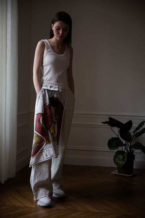 Dalva is wearing White Canvas sustainable light grey color, genderless, seasonless casual checks trousers, size S. The Essential checks trousers have minimal modern aesthetics design allowing comfort and bringing self-confidence. This unique piece is made locally in Paris to reduce environmental impact and guarantee high quality and durability of the products.