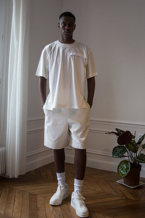 Thierno is wearing White Canvas sustainable off white cotton jersey oversized, genderless, seasonless t-shirt, one size. The off white cotton jersey t-shirt has minimal modern aesthetics design allowing comfort and bringing self-confidence. This unique piece is made locally in Paris to reduce environmental impact and guarantee high quality and durability of the products.