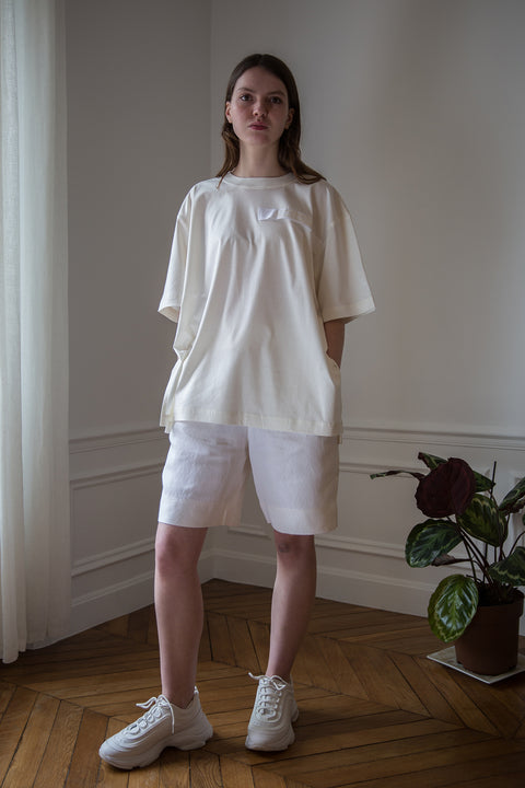 Dalva is wearing White Canvas sustainable off white cotton jersey oversized, genderless, seasonless t-shirt, one size. The off white cotton jersey t-shirt has minimal modern aesthetics design allowing comfort and bringing self-confidence. This unique piece is made locally in Paris to reduce environmental impact and guarantee high quality and durability of the products.