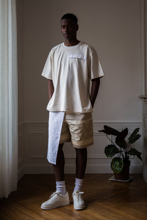 Thierno is wearing White Canvas sustainable natural cotton jersey oversized, genderless, seasonless t-shirt, one size. The natural cotton jersey t-shirt has minimal modern aesthetics design allowing comfort and bringing self-confidence. This unique piece is made locally in Paris to reduce environmental impact and guarantee high quality and durability of the products.