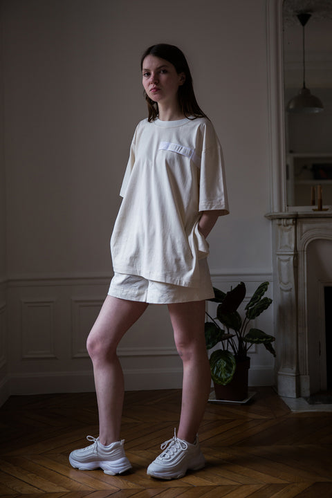Dalva is wearing White Canvas sustainable natural cotton jersey oversized, genderless, seasonless t-shirt, one size. The natural cotton jersey t-shirt has minimal modern aesthetics design allowing comfort and bringing self-confidence. This unique piece is made locally in Paris to reduce environmental impact and guarantee high quality and durability of the products.