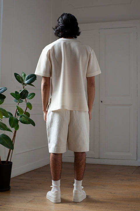 Medhi is wearing White Canvas sustainable mesh oversized, genderless, seasonless t-shirt, one size. The mesh t-shirt has minimal modern aesthetics design allowing comfort and bringing self-confidence. This unique piece is made locally in Paris to reduce environmental impact and guarantee high quality and durability of the products.
