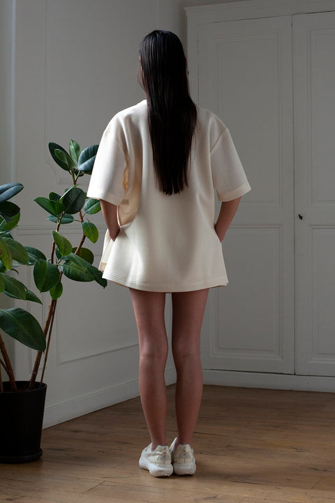 SiJia is wearing White Canvas sustainable mesh oversized, genderless, seasonless t-shirt, one size. The mesh t-shirt has minimal modern aesthetics design allowing comfort and bringing self-confidence. This unique piece is made locally in Paris to reduce environmental impact and guarantee high quality and durability of the products.