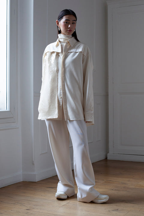 SiJia is wearing the White Canvas essentails wool trousers and organic cotton oversized gender neutral shirt styled with the sequins vertical fabric panel made from leftover deadstock fabrics. The sequins panel is an exclusive unique sustainable piece made in France. It is made to be attached to the essential pieces to personalize them and wear them your unique way.