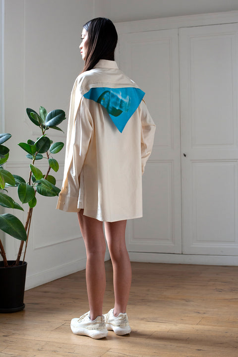 SiJia is wearing the White Canvas essential shirt styled with the Glass triangular panel and bandana made from deadstock cotton poplin. The bandana has an exclusive print of a photo by the photographer Henrique Soares. Attach the panel to the essential pieces to personalize them and wear them your unique way. It is the perfect creative summer accessory.