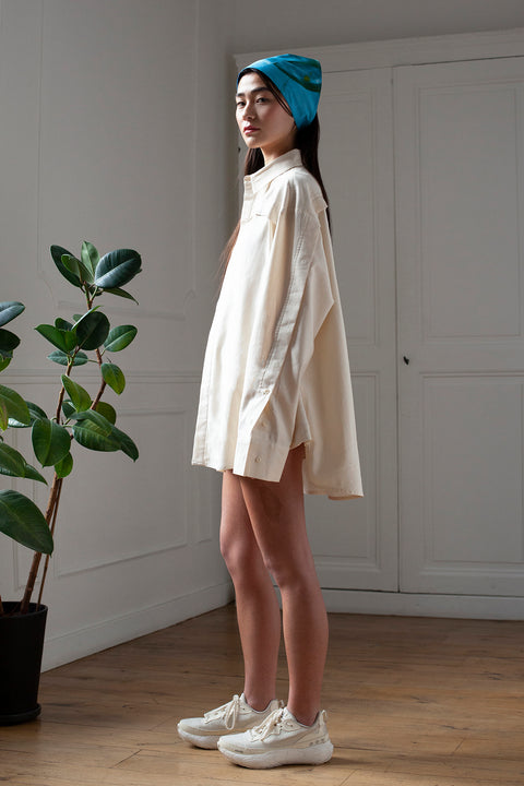 SiJia is wearing the White Canvas essential shirt styled with the Glass triangular panel and bandana made from deadstock cotton poplin. The bandana has an exclusive print of a photo by the photographer Henrique Soares. Attach the panel to the essential pieces to personalize them and wear them your unique way. It is the perfect creative summer accessory.