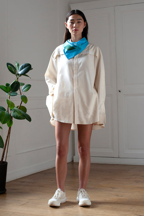 SiJia is wearing the White Canvas essential shirt styled with the Glass triangular panel and bandana made from deadstock cotton poplin. The bandana has an exclusive print of a photo by the photographer Henrique Soares. Attach the panel to the essential pieces to personalize them and wear them your unique way. It is the perfect creative summer accessory.