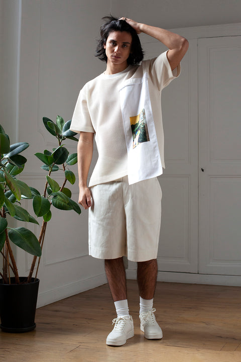 Medhi is wearing the White Canvas mesh t-shirt styled with the Flower guy vertical panel made from deadstock cotton poplin. The panel has an exclusive print of a photo by the photographer Henrique Soares. Attach the panel to the essential pieces to personalize them and wear them your unique way. It is the perfect creative summer accessory.