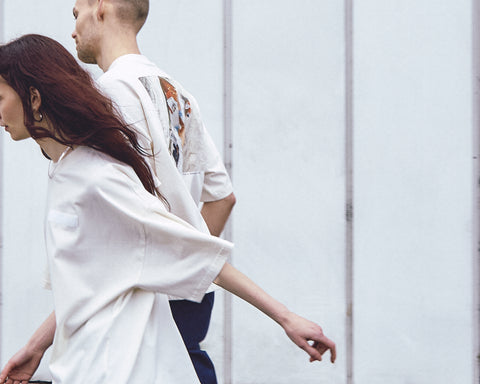 Two models are wearing the White Canvas Originals sustainable, oversized, genderless t-shirt, one size. The organic cotton natural color t-shirt has minimal modern aesthetics design allowing comfort and bringing self-confidence. This limited edition collection is made in Portugal to reduce environmental impact and guarantee high quality and durability of the products. There is a photo by the photographer Henrique Soares at the back of the t-shirt.