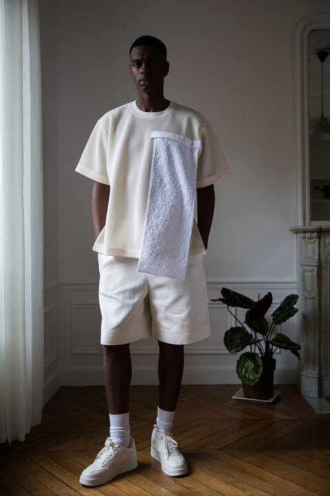 The white tweed panel is an exclusive unique sustainable piece made in France. It is made to be attached to the essential pieces to personalize them and wear them your unique way.