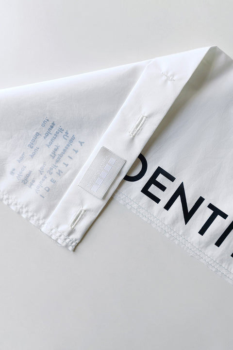 Detail. The White Canvas white cotton poplin fabric panel made from leftover deadstock fabrics and with black artisanal eco-friendly screen print done locally in Paris in collaboration with RoStudio. Attach the panel to the essential pieces to personalize them and wear them your unique way