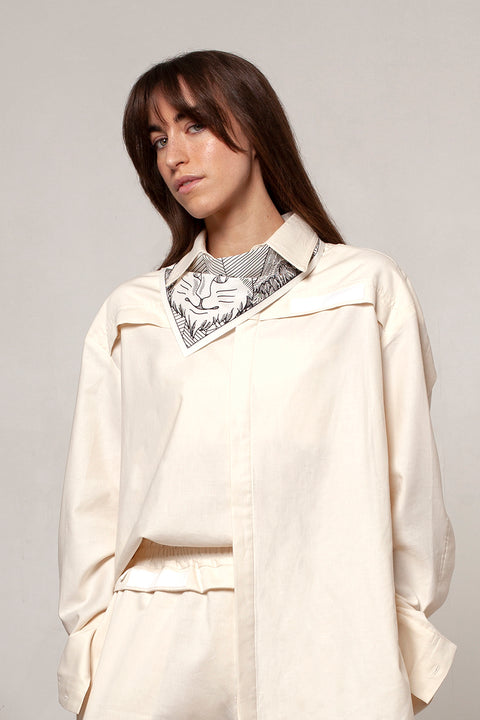 Léa is wearing the White Canvas ESSENTIAL SHIRT styled with THE TWO OF CUPS triangular panel & bandana made from leftover deadstock white cotton poplin. The bandana has an exclusive design inspired by tarot cards drawn by the artist Maria Robla and printed with black artisanal eco-friendly ink locally in Paris in collaboration with RoStudio. Wear the black and white bandana alone or attach it to the essential pieces to personalize them and wear them your unique way. Your perfect summer accessory.