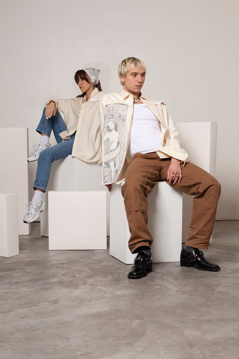 Clément is wearing the White Canvas ESSENTIAL SHIRT styled with THE WORLD vertical panel made from leftover deadstock white cotton poplin. The panel has an exclusive design inspired by tarot cards drawn by the artist Maria Robla and printed with black artisanal eco-friendly ink locally in Paris in collaboration with RoStudio. Attach the black and white panel to the essential pieces to personalize them and wear them your unique way. Your perfect summer accessory.