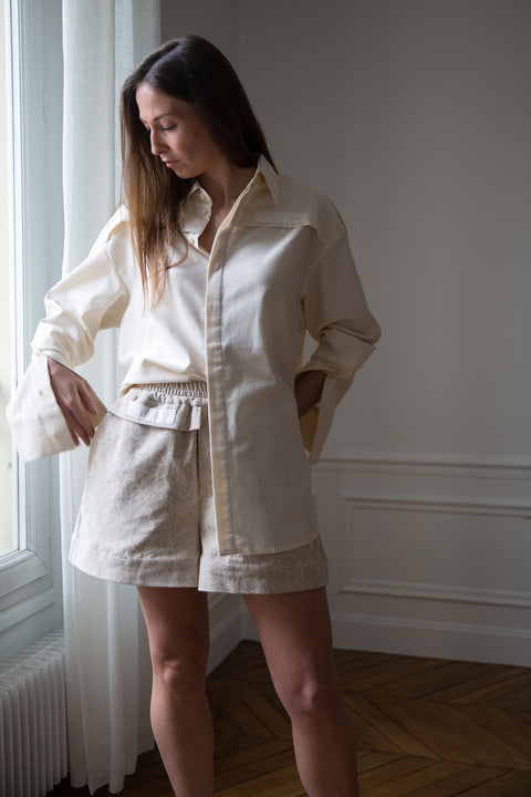 Lena is wearing White Canvas sustainable  jacquard short shorts, size S. The jacquard short shorts have minimal modern aesthetics design allowing comfort and bringing self-confidence. This unique piece is made locally in Paris to reduce environmental impact and guarantee high quality and durability of the products.