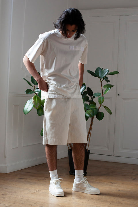 Medhi is wearing White Canvas sustainable denim genderless casual shorts, size M. The denim shorts have minimal modern aesthetics design allowing comfort and bringing self-confidence. This unique piece is made locally in Paris to reduce environmental impact and guarantee high quality and durability of the products.