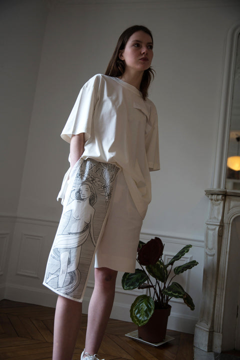 Dalva is wearing White Canvas sustainable textured genderless casual shorts, size S. The textured shorts have minimal modern aesthetics design allowing comfort and bringing self-confidence. This unique piece is made locally in Paris to reduce environmental impact and guarantee high quality and durability of the products.