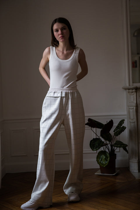 Dalva is wearing White Canvas sustainable light grey color, genderless, seasonless casual checks trousers, size S. The Essential checks trousers have minimal modern aesthetics design allowing comfort and bringing self-confidence. This unique piece is made locally in Paris to reduce environmental impact and guarantee high quality and durability of the products.