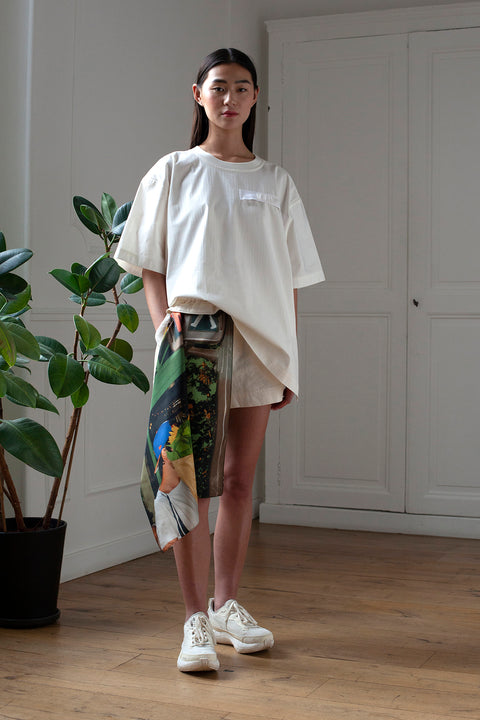 SiJia is wearing White Canvas sustainable white, oversized, genderless, seasonless t-shirt, one size. The cotton stripes t-shirt has minimal modern aesthetics design allowing comfort and bringing self-confidence. This unique piece is made locally in Paris to reduce environmental impact and guarantee high quality and durability of the products. 