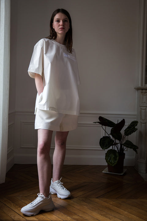 Dalva is wearing White Canvas sustainable white, oversized, genderless, seasonless t-shirt, one size. The cotton textured t-shirt has minimal modern aesthetics design allowing comfort and bringing self-confidence. This unique piece is made locally in Paris to reduce environmental impact and guarantee high quality and durability of the products. 