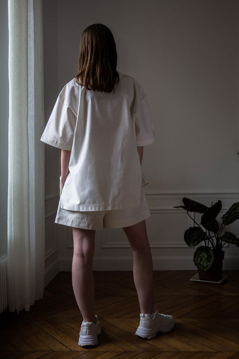 Dalva is wearing White Canvas sustainable white, oversized, genderless, seasonless t-shirt, one size. The cotton textured t-shirt has minimal modern aesthetics design allowing comfort and bringing self-confidence. This unique piece is made locally in Paris to reduce environmental impact and guarantee high quality and durability of the products. 