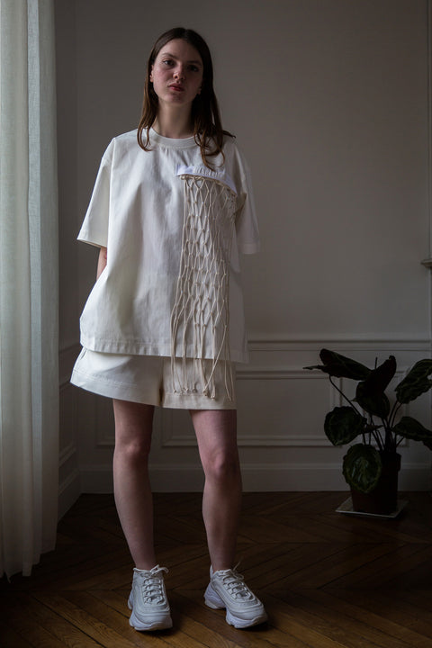 Dalva is wearing White Canvas sustainable white, oversized, genderless, seasonless t-shirt, one size. The cotton textured t-shirt has minimal modern aesthetics design allowing comfort and bringing self-confidence. This unique piece is made locally in Paris to reduce environmental impact and guarantee high quality and durability of the products. 