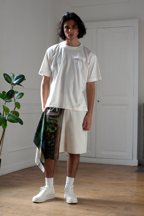 Medhi is wearing White Canvas sustainable off white cotton jersey oversized, genderless, seasonless t-shirt, one size. The off white cotton jersey t-shirt has minimal modern aesthetics design allowing comfort and bringing self-confidence. This unique piece is made locally in Paris to reduce environmental impact and guarantee high quality and durability of the products. 