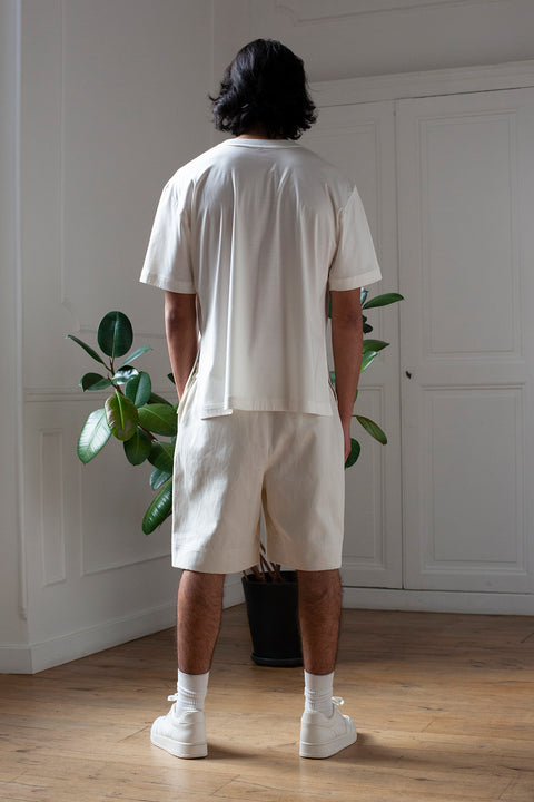 Medhi is wearing White Canvas sustainable off white cotton jersey oversized, genderless, seasonless t-shirt, one size. The off white cotton jersey t-shirt has minimal modern aesthetics design allowing comfort and bringing self-confidence. This unique piece is made locally in Paris to reduce environmental impact and guarantee high quality and durability of the products. 