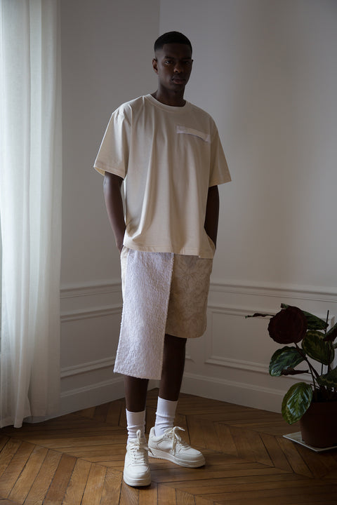 Thierno is wearing White Canvas sustainable natural cotton jersey oversized, genderless, seasonless t-shirt, one size. The natural cotton jersey t-shirt has minimal modern aesthetics design allowing comfort and bringing self-confidence. This unique piece is made locally in Paris to reduce environmental impact and guarantee high quality and durability of the products. 
