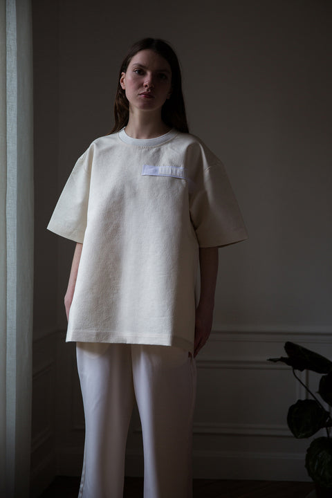 Dalva is wearing White Canvas sustainable floral jacquard oversized, genderless, seasonless t-shirt, one size. The floral jacquard t-shirt has minimal modern aesthetics design allowing comfort and bringing self-confidence. This unique piece is made locally in Paris to reduce environmental impact and guarantee high quality and durability of the products. 