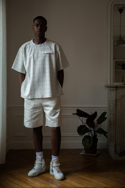 Thierno is wearing White Canvas sustainable checks oversized, genderless, seasonless t-shirt, one size. The checks t-shirt has minimal modern aesthetics design allowing comfort and bringing self-confidence. This unique piece is made locally in Paris to reduce environmental impact and guarantee high quality and durability of the products. 