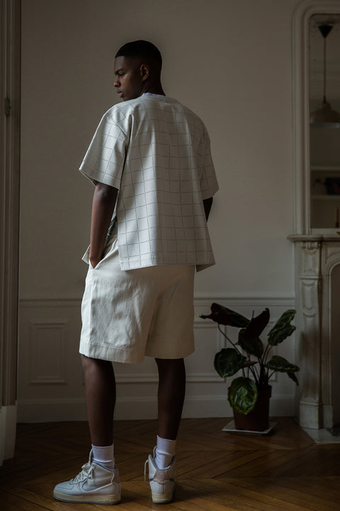 Thierno is wearing White Canvas sustainable checks oversized, genderless, seasonless t-shirt, one size. The checks t-shirt has minimal modern aesthetics design allowing comfort and bringing self-confidence. This unique piece is made locally in Paris to reduce environmental impact and guarantee high quality and durability of the products. 