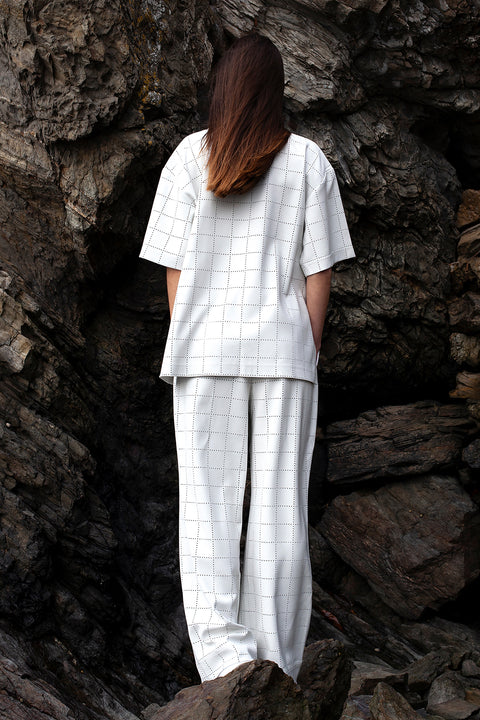 Romane is wearing White Canvas sustainable light grey color, genderless, seasonless casual checks trousers, size S. The Essential checks trousers have minimal modern aesthetics design allowing comfort and bringing self-confidence. This unique piece is made locally in Paris to reduce environmental impact and guarantee high quality and durability of the products. 