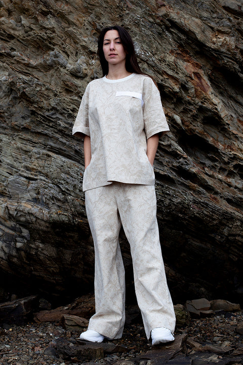 Romane is wearing White Canvas jacquard natural color, oversized, genderless, seasonless casual t-shirt, one size. The Essential jacquard t-shirt has minimal modern aesthetics design allowing comfort and bringing self-confidence. This unique piece is made locally in Paris to reduce environmental impact and guarantee high quality and durability of the products. 