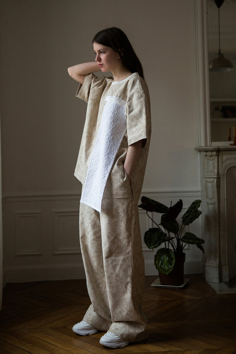 Dalva is wearing White Canvas jacquard natural color, oversized, genderless, seasonless casual t-shirt, one size. The Essential jacquard t-shirt has minimal modern aesthetics design allowing comfort and bringing self-confidence. This unique piece is made locally in Paris to reduce environmental impact and guarantee high quality and durability of the products. 