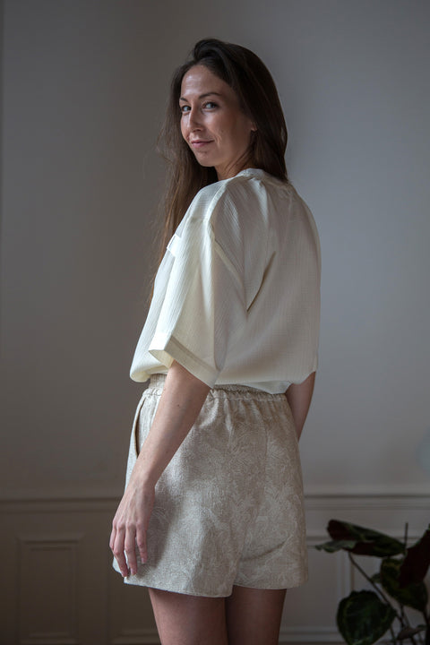 Lena is wearing White Canvas sustainable light weight oversized, genderless, seasonless t-shirt, one size. The light weight t-shirt has minimal modern aesthetics design allowing comfort and bringing self-confidence. This unique piece is made locally in Paris to reduce environmental impact and guarantee high quality and durability of the products. 