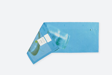 The glass horizontal panel is made from deadstock cotton poplin. The panel has an exclusive print of a photo by the photographer Henrique Soares. Attach the panel to the essential pieces to personalize them and wear them your unique way. It is the perfect creative summer accessory.