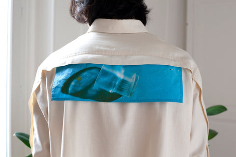 Medhi is wearing the White Canvas ESSENTIAL SHIRT styled with the glass horizontal panel made from deadstock white cotton poplin. The panel has an exclusive print of a photo by the photographer Henrique Soares. Attach the panel to the essential pieces to personalize them and wear them your unique way. It is the perfect creative summer accessory.