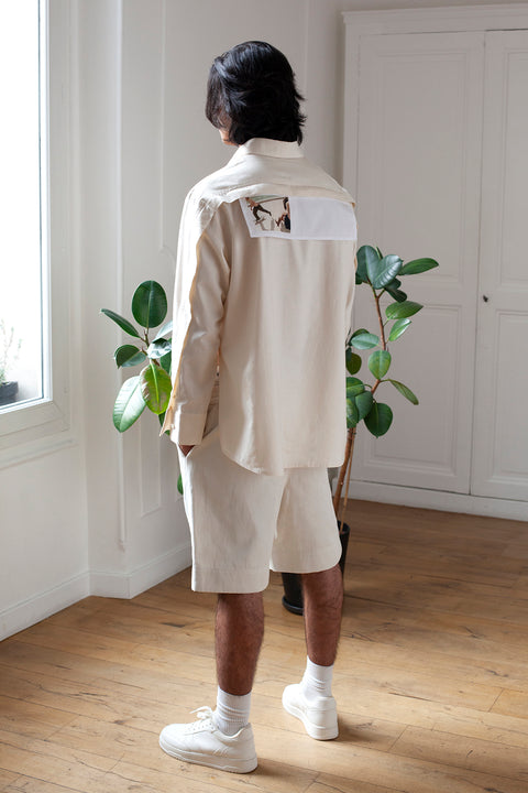 Medhi is wearing the White Canvas ESSENTIAL SHIRT styled with the Skater horizontal panel made from deadstock white cotton poplin. The panel has an exclusive print of a photo by the photographer Henrique Soares. Attach the panel to the essential pieces to personalize them and wear them your unique way. It is the perfect creative summer accessory.