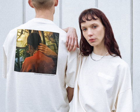 Two models are wearing the White Canvas Originals sustainable, oversized, genderless t-shirt, one size. The organic cotton natural color t-shirt has minimal modern aesthetics design allowing comfort and bringing self-confidence. This limited edition collection is made in Portugal to reduce environmental impact and guarantee high quality and durability of the products. There is a photo by the photographer Henrique Soares at the back of the t-shirt.