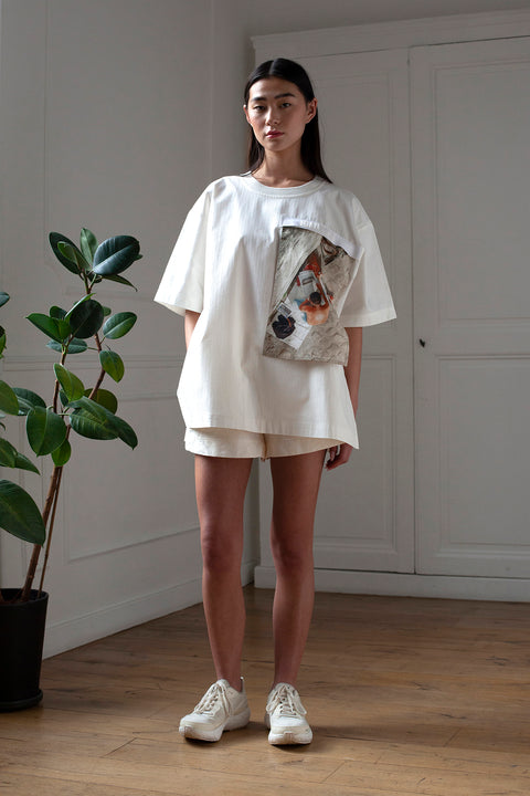 SiJia is wearing the White Canvas cotton stripes t-shirt styled with the Newspaper vertical panel made from deadstock cotton poplin. The panel has an exclusive print of a photo by the photographer Henrique Soares. Attach the panel to the essential pieces to personalize them and wear them your unique way. It is the perfect creative summer accessory.
