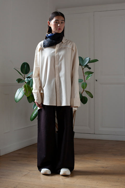 SiJia is wearing the White Canvas ESSENTIAL SHIRT styled with the Shadows foulard and square panel made from a qualitative silk fabric. The foulard is printed in France with an exclusive photo by the photographer Henrique Soares. Wear the foulard alone or attach it to the essential pieces to personalize them and wear them your unique way. Your perfect summer accessory. White Canvas x Henrique Soares creative collaboration.