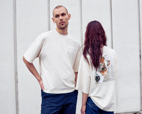 Two models are wearing the White Canvas Originals sustainable, oversized, genderless t-shirt, one size. The organic cotton natural color t-shirt has minimal modern aesthetics design allowing comfort and bringing self-confidence. This limited edition collection is made in Portugal to reduce environmental impact and guarantee high quality and durability of the products. There is a photo by the photographer Henrique Soares at the back of the t-shirt.