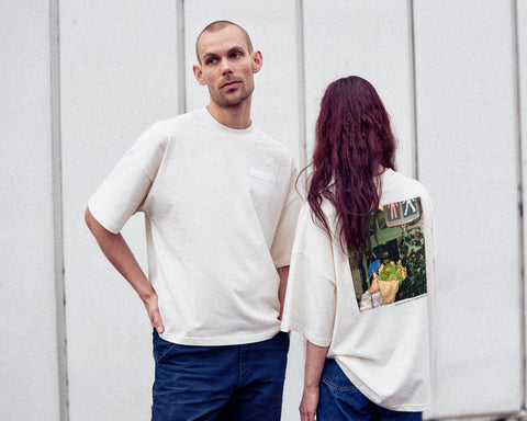 Two models are wearing the White Canvas Originals sustainable, oversized, genderless t-shirt, one size. The organic cotton natural color t-shirt has minimal modern aesthetics design allowing comfort and bringing self-confidence. This limited edition collection is made in Portugal to reduce environmental impact and guarantee high quality and durability of the products. There is a photo by the photographer Henrique Soares at the back of the t-shirt.