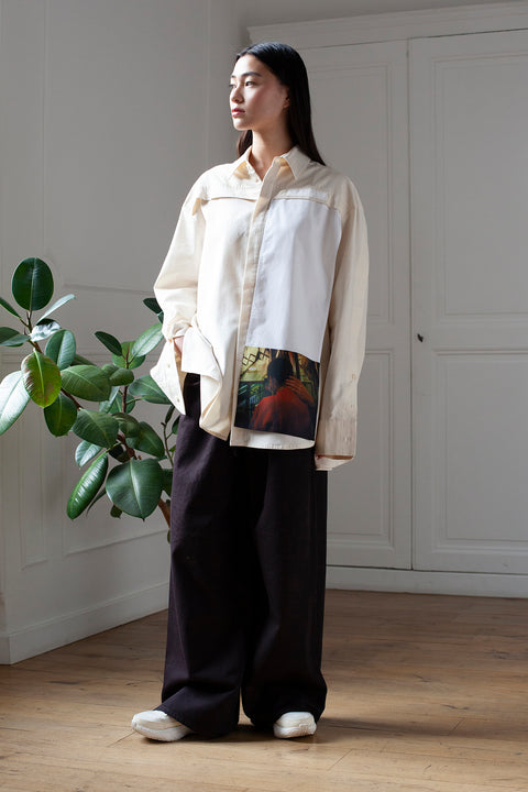 SiJia is wearing the White Canvas organic cotton essential shirt styled with the Hand vertical panel made from deadstock cotton poplin. The panel has an exclusive print of a photo by the photographer Henrique Soares. Attach the panel to the essential pieces to personalize them and wear them your unique way. It is the perfect creative summer accessory.