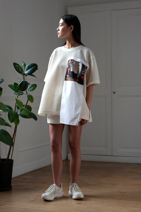 SiJia is wearing the White Canvas mesh t-shirt styled with the Trench Coat vertical panel made from deadstock cotton poplin. The panel has an exclusive print of a photo by the photographer Henrique Soares. Attach the panel to the essential pieces to personalize them and wear them your unique way. It is the perfect creative summer accessory.