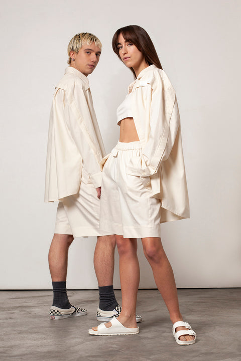 Léa and Clément are wearing the White Canvas Essentials : sustainable natural beige color, organic cotton, genderless, inclusive, casual shirt and short, offered in sizes from S to XXXL. The Essentials have minimal modern aesthetics design allowing comfort and bringing self-confidence. A limited-edition production is made locally in France to reduce environmental impact and guarantee high quality and durability of the products. 