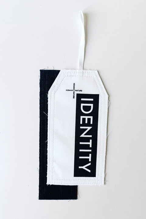The White Canvas limited edition tag made in white and black cotton poplin leftover deadstock fabrics and with black artisanal eco-friendly screen print done locally in Paris in collaboration with RoStudio. Attach the panel to the essential pieces to personalize them and wear them your unique way. The tag is sold with key holder in recycled plastic made in collaboration with Samji Atelier