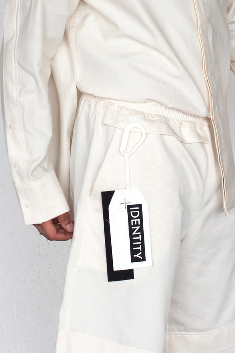 The White Canvas ESSENTIAL SHIRT and SHORT with a limited edition tag made in white and black cotton poplin leftover deadstock fabrics and with black artisanal eco-friendly screen print done locally in Paris in collaboration with RoStudio. Attach the panel to the essential pieces to personalize them and wear them your unique way. The tag is sold with key holder in recycled plastic made in collaboration with Samji Atelier