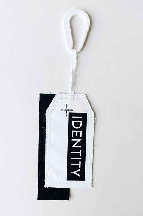 The White Canvas limited edition tag made in white and black cotton poplin leftover deadstock fabrics and with black artisanal eco-friendly screen print done locally in Paris in collaboration with RoStudio. Attach the panel to the essential pieces to personalize them and wear them your unique way. The tag is sold with key holder in recycled plastic made in collaboration with Samji Atelier