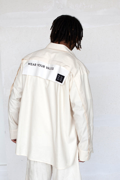 The White Canvas ESSENTIAL SHIRT with white cotton poplin fabric panel made from leftover deadstock fabrics and with black patch and artisanal eco-friendly screen print done locally in Paris in collaboration with RoStudio. Attach the panel to the essential pieces to personalize them and wear them your unique way